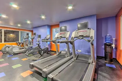 a gym with several tread machines in a room at Oceanfront PCB Resort Condo with Balcony and Views! in Panama City Beach