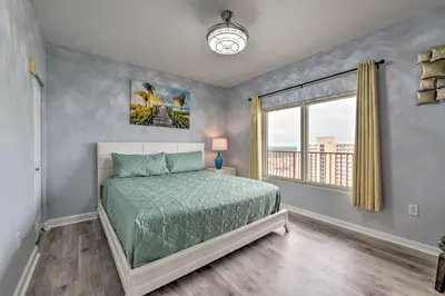 a bedroom with a bed and a window at Oceanfront PCB Resort Condo with Balcony and Views! in Panama City Beach