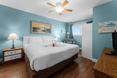 a bedroom with a large bed with a ceiling fan at The Summit 726 in Panama City Beach