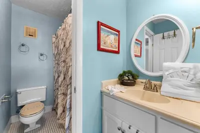 a bathroom with a sink and a toilet and a mirror at The Summit 726 in Panama City Beach