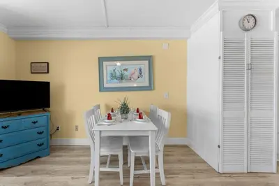 a dining room with a white table and chairs at The Summit 726 in Panama City Beach