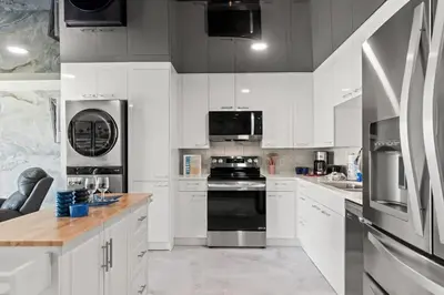 a kitchen with white cabinets and black appliances at The Summit 306 in Panama City Beach
