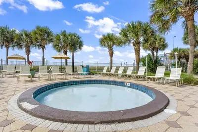 a swimming pool with chairs and palm trees at The Summit 306 in Panama City Beach