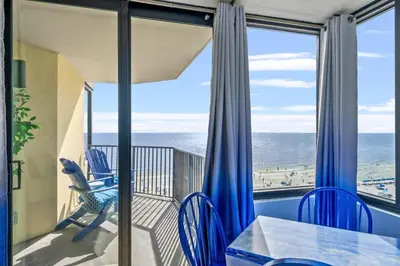 a balcony with a table and chairs and a view of the beach at Sunbird 811E in Panama City Beach