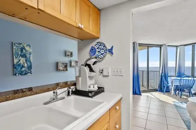 a kitchen with a sink and a view of the ocean at Sunbird 811E in Panama City Beach