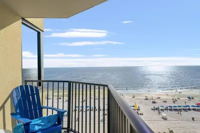a balcony with a blue chair and the beach at Sunbird 811E in Panama City Beach