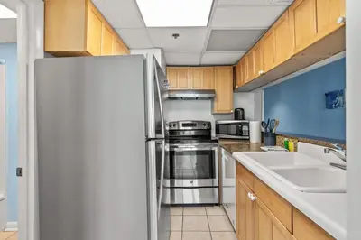 a kitchen with a refrigerator and a sink at Sunbird 811E in Panama City Beach