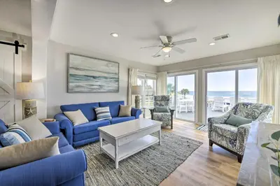 a living room with a blue couch and chairs at Breezy PCB Retreat with Direct Beach Access! in Panama City Beach