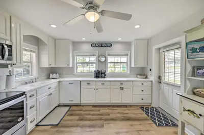a kitchen with white cabinets and a ceiling fan at Breezy PCB Retreat with Direct Beach Access! in Panama City Beach