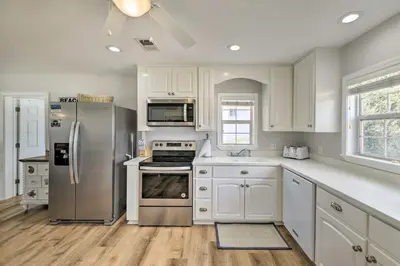 a kitchen with white cabinets and stainless steel appliances at Breezy PCB Retreat with Direct Beach Access! in Panama City Beach