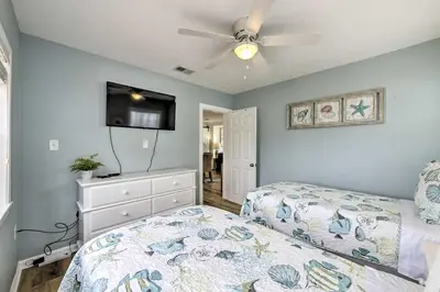 a bedroom with a bed and a flat screen tv at Breezy PCB Retreat with Direct Beach Access! in Panama City Beach