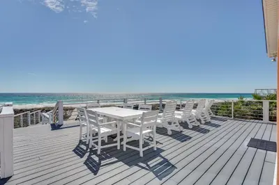 a table and chairs on a deck with the beach at Breezy PCB Retreat with Direct Beach Access! in Panama City Beach