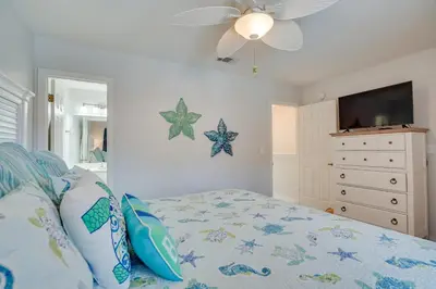 a bedroom with a bed and a ceiling fan at Sun-Dappled PCB Retreat with Multiple Pools! in Panama City Beach