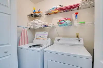 a small laundry room with a washer and dryer at Sun-Dappled PCB Retreat with Multiple Pools! in Panama City Beach