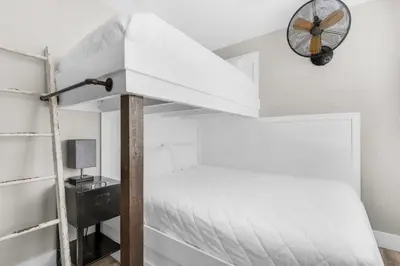 a bedroom with a bunk bed and a fan at Sand Castles West II G4- FinView in Panama City Beach