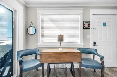 a dining room with two blue chairs and a wooden table at Sand Castles West II G4- FinView in Panama City Beach