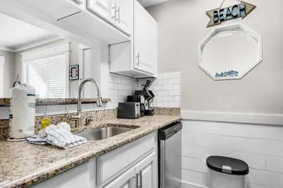 a kitchen with white cabinets and a sink at Sand Castles West II G4- FinView in Panama City Beach