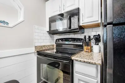 a kitchen with a stove and a microwave at Sand Castles West II G4- FinView in Panama City Beach