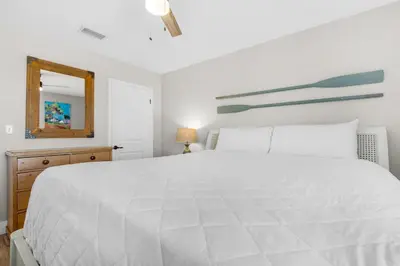 a bedroom with a large white bed and a mirror at Sand Castles West II G4- FinView in Panama City Beach