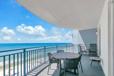 a balcony with a table and chairs and the ocean at Sterling Breeze 904 in Panama City Beach