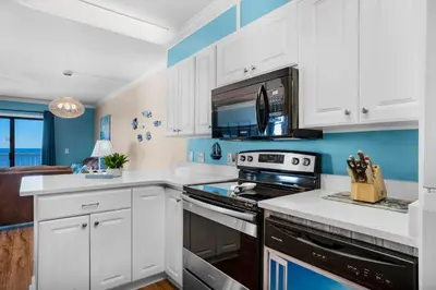 a kitchen with white cabinets and a stove top oven at The Summit 1432 in Panama City Beach