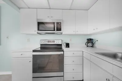 a white kitchen with a stove and a microwave at Edgewater Tower 2-307 in Panama City Beach