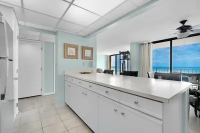 a kitchen with a large white counter with a view of the ocean at Edgewater Tower 2-307 in Panama City Beach