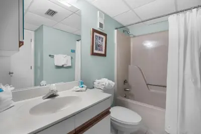 a bathroom with a sink and a toilet and a mirror at Edgewater Tower 2-307 in Panama City Beach