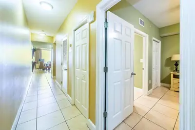 a hallway with green walls and white doors at Majestic Beach Towers 1-1706 in Panama City Beach
