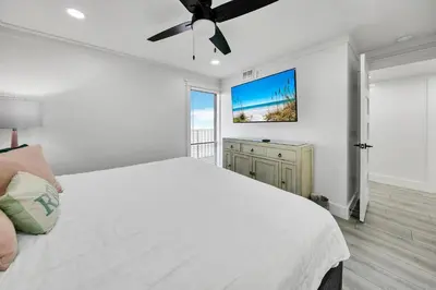 a bedroom with a white bed and a ceiling fan at Edgewater Tower 2-407 in Panama City Beach
