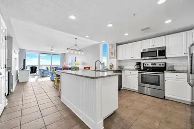 a kitchen with white cabinets and a large counter top at Majestic Beach Towers 2-1701 in Panama City Beach