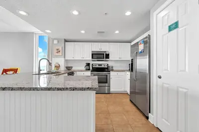 a kitchen with white cabinets and a stainless steel refrigerator at Majestic Beach Towers 2-1701 in Panama City Beach
