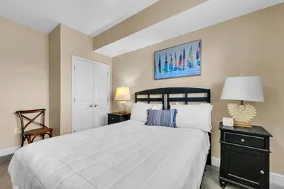 a bedroom with a large bed and a lamp at Sterling Breeze 802 in Panama City Beach