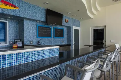 a restaurant with a bar with blue tiles at Sterling Breeze 802 in Panama City Beach