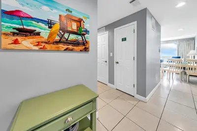 a living room with a painting on the wall at Splash 1802E in Panama City Beach