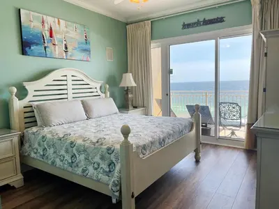 a bedroom with a bed and a view of the ocean at Sterling Beach #602 in Panama City Beach