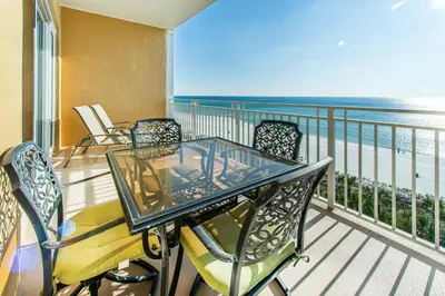 a glass table and chairs on a balcony with the ocean at Sterling Beach #602 in Panama City Beach