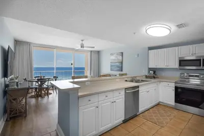 a kitchen with white cabinets and a view of the ocean at Majestic Beach Towers 1-314 in Panama City Beach