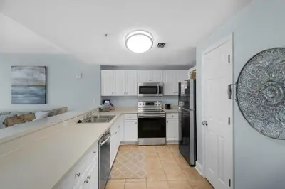 a white kitchen with white cabinets and appliances at Majestic Beach Towers 1-314 in Panama City Beach