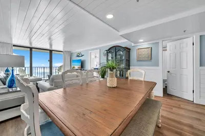 a dining room and living room with a table and chairs at Edgewater Tower 3-412 in Panama City Beach