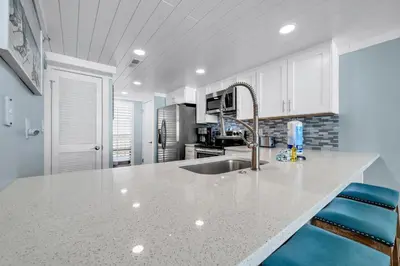 a kitchen with a white counter top and a sink at Edgewater Tower 3-412 in Panama City Beach
