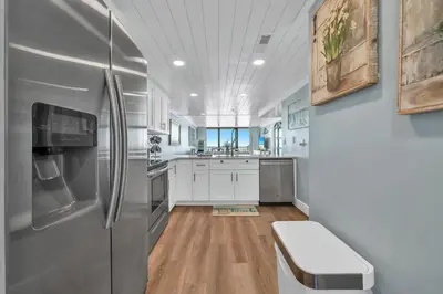 a kitchen with stainless steel refrigerator and white cabinets at Edgewater Tower 3-412 in Panama City Beach