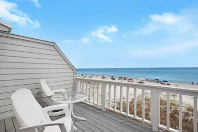 a balcony with a table and chairs and the beach at SeaRenity at Inlet 2 in Panama City Beach