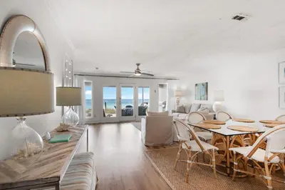 a living room with a table and chairs and a dining room at SeaRenity at Inlet 2 in Panama City Beach