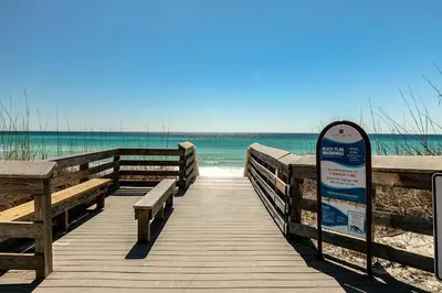 a boardwalk leading to the beach with a sign at Cassine Gardens 108- Sandy Daze in Santa Rosa Beach
