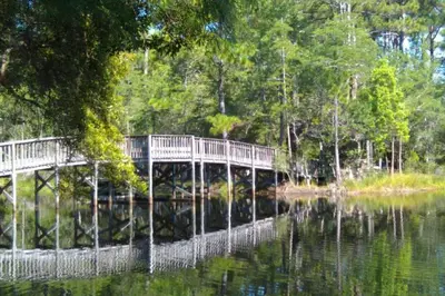a bridge over a body of water with trees at Cassine Gardens 108- Sandy Daze in Santa Rosa Beach
