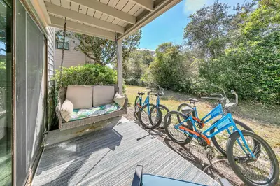 two bikes parked on a porch with a couch at Cassine Gardens 108- Sandy Daze in Santa Rosa Beach