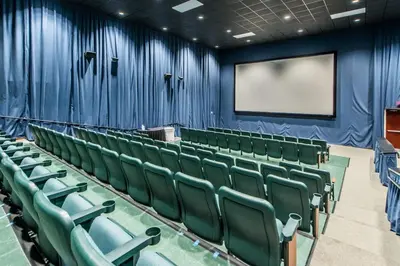an empty auditorium with green chairs and a screen at Majestic Beach Towers 1-2314 in Panama City Beach