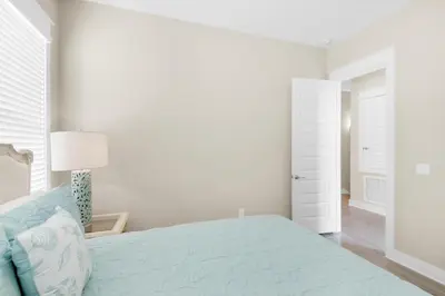 a white bedroom with a bed and a white door at Town of Prominence 326B- Seaside Paradise in Santa Rosa Beach