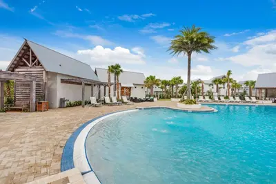 a swimming pool in front of a house with palm trees at Town of Prominence 326B- Seaside Paradise in Santa Rosa Beach